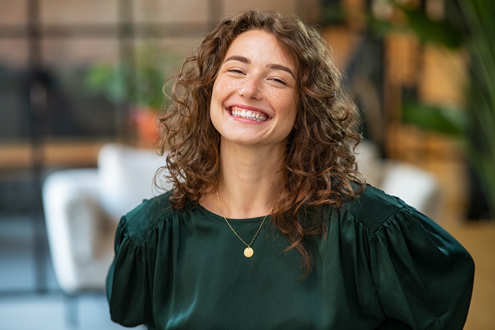 Portrait of beautiful young woman laughing at creative office